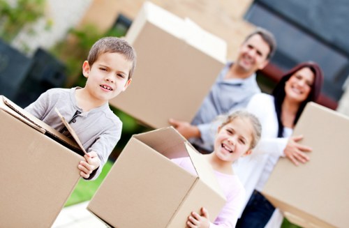 Local movers carrying furniture through a Mileend property